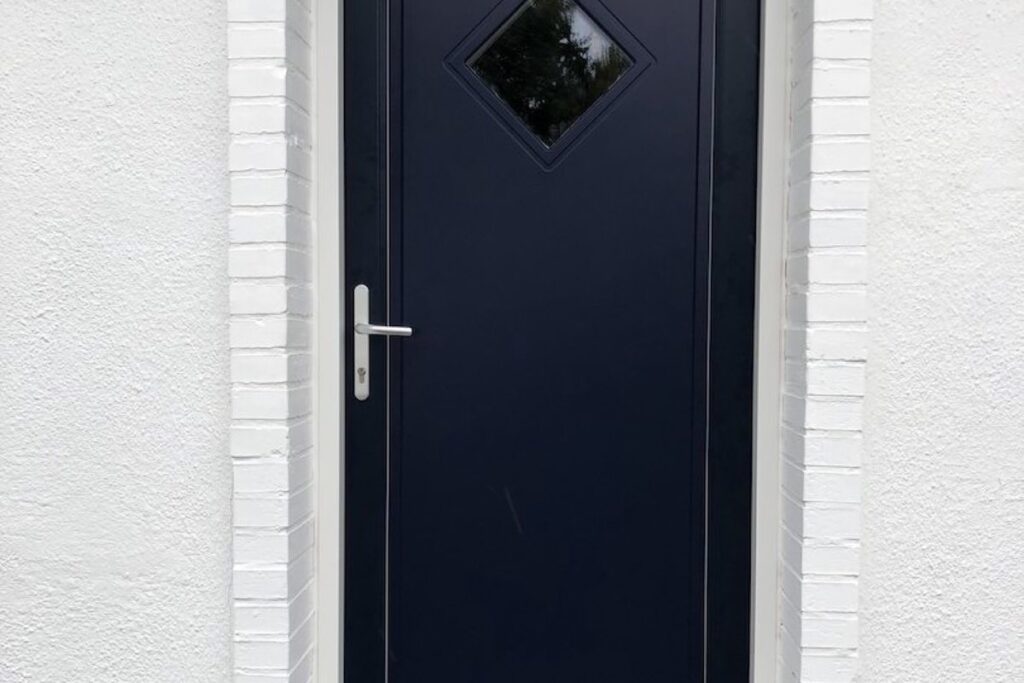 Mørkeblå hoveddør monteret i hvid facade i Skagen