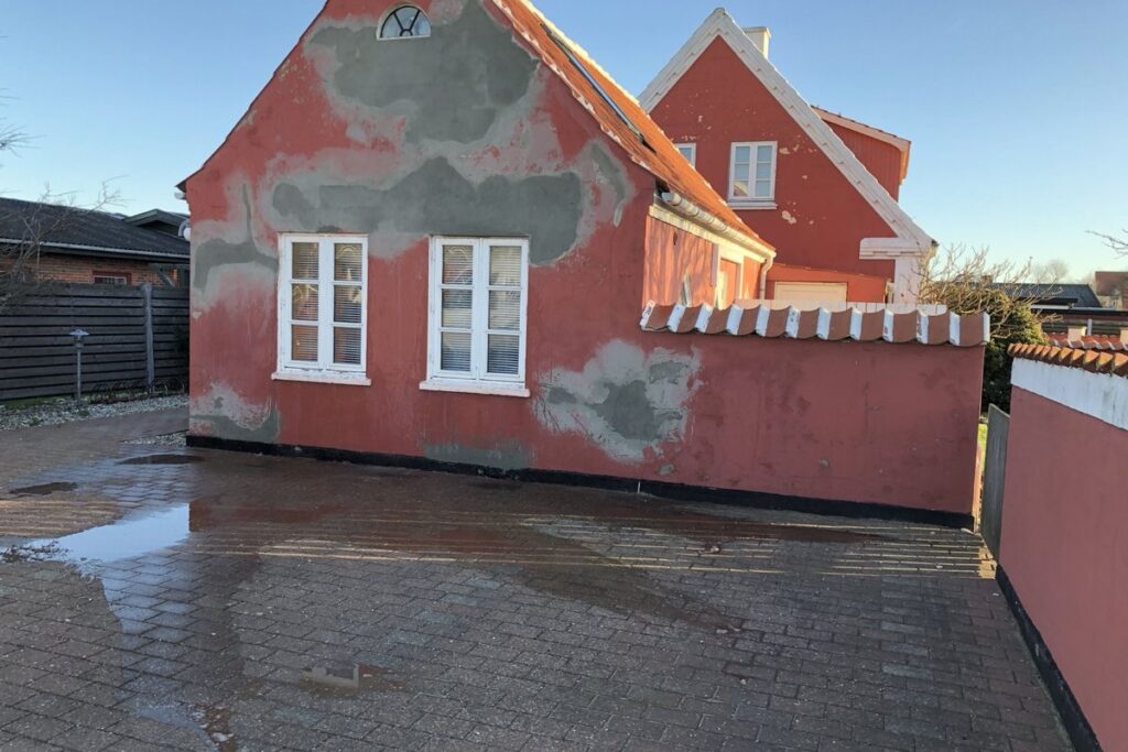 Rødt hus med facade under afrensning og renovering i Skagen