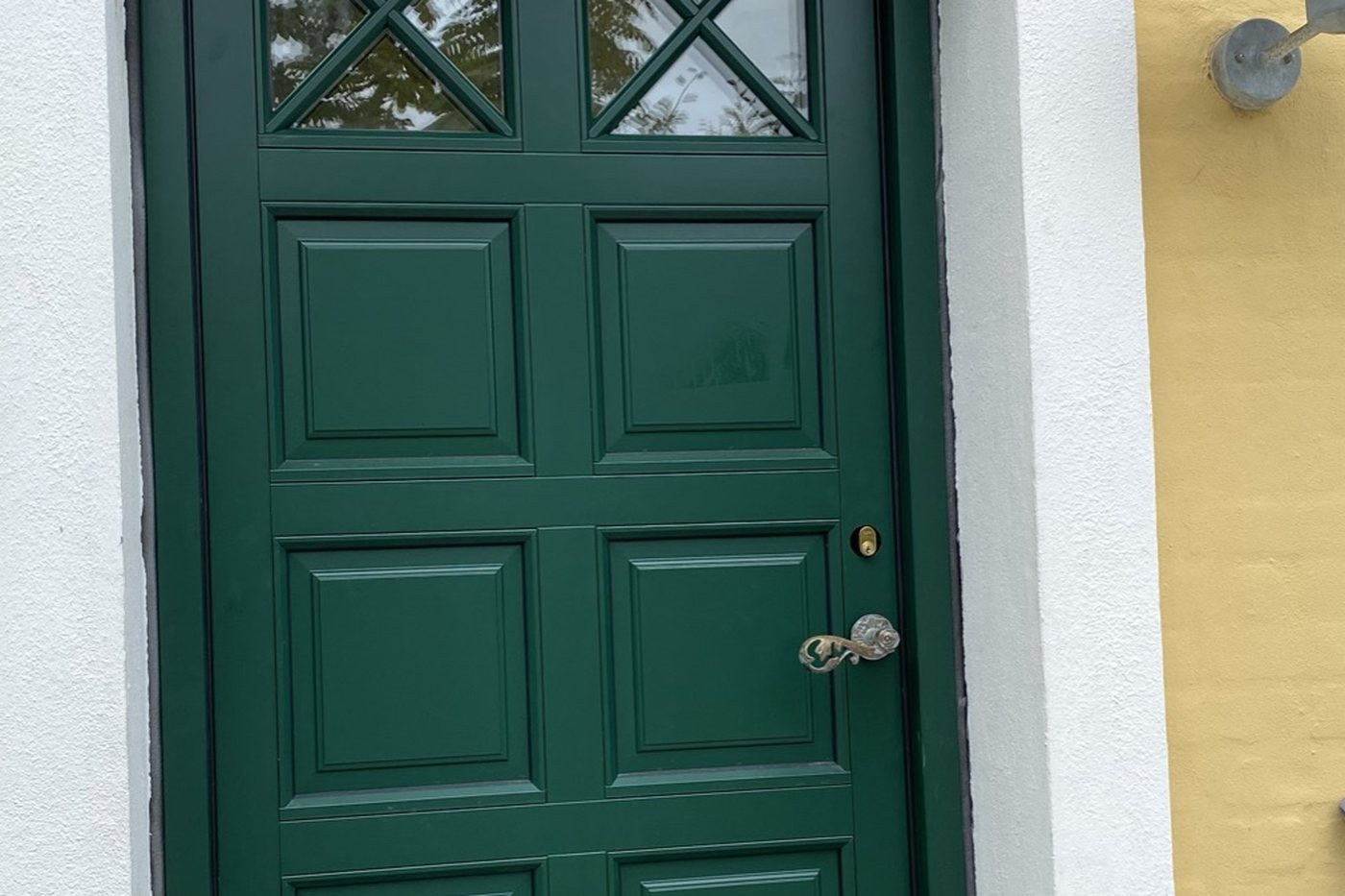 Ny grøn hoveddør monteret i hvid facade i Skagen